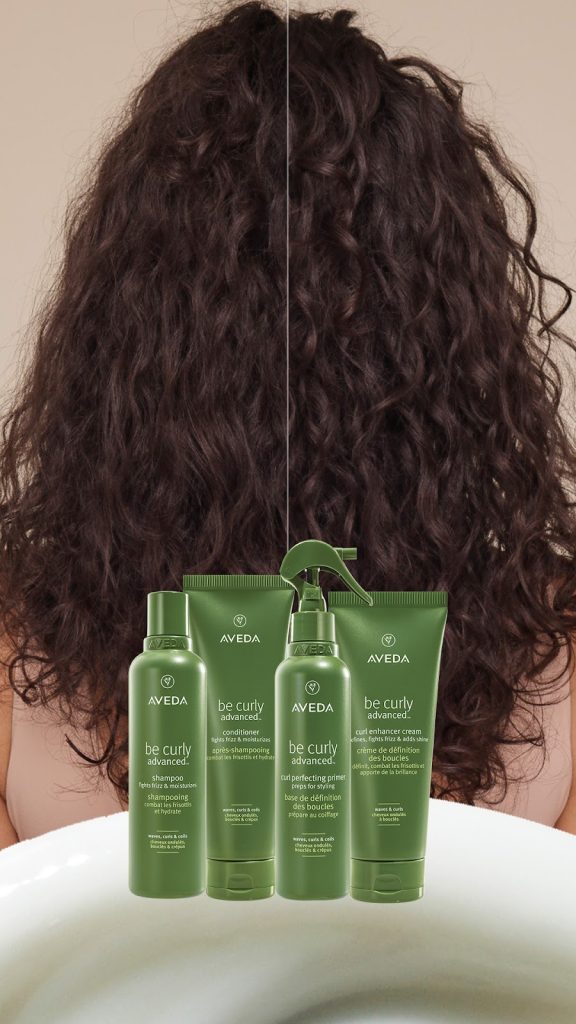Comparison of curly hair before and after using aveda be curly products, displayed in front of the person's head with three product bottles. - Scott J Salons in New York, NY