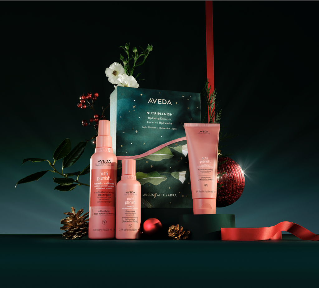 Aveda Nutriplenish hair care gift set with shampoo, conditioner, and leave-in treatment displayed with holiday-themed decorations. - Scott J Salons in New York, NY